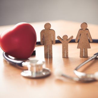 wooden figures of family with heart and stethoscope