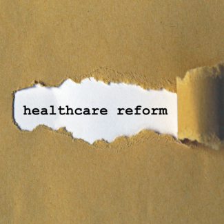 text 'healthcare reform' revealed under torn paper