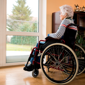 elderly woman in wheelchair looking out a window